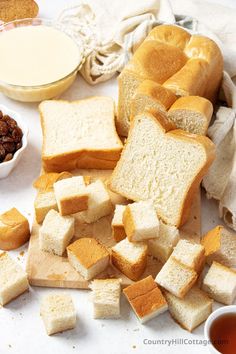 sliced bread and raisins on a cutting board next to a bowl of milk