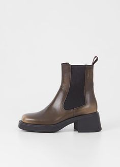 Dorah is the contemporary Chelsea boots for everyday wear. The style is crafted in black leather featuring a square-toe shape, elastic side panels and pull-on tabs. The chunky block heels measure 59mm. Black leather Square toe shape Elastic side panels 59mm block heels For long-lasting care: use black shoe cream and protector spray to ensure a great condition of the shoes. Fitting (based on size 37) True to size Shaft height: 182 mm Shaft width: 235 mm Heel height: 59 mm Article no.: 5642-001-20 Vagabond Shoes, Clogs Heels, Neutral Shoes, Cream Shoes, Autumn Outfits, Chunky Block Heels, Black Boots Women, Chunky Boots, Sandals For Sale