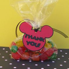 a bag filled with gummy bears sitting on top of a table next to a sign that says thank you