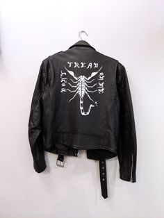 "This is a vintage black leather moto jacket hand painted with a Scorpio inspired design. It has a removable lining so you can wear it all winter long, you punk.   It's completely one of a kind and ready to be sweat in and spilled on at shows in dive bars. size marked: 38  fits like: men's medium or women's large / oversized women's medium. It is a men's jacket, though, so the torso is straight and a little longer than women's jackets are usually cut. bust: 19\" waist: 15.5\" overall length: 24.5\" sleeve length: 26\" all measurements are taken flat across the garment and not doubled. For the best idea of how this will fit you, compare the measurements to one of your favorite jackets, or (if you live in the Columbus, Ohio area), message me and we can work out a time for you to come try it Scorpio Vintage, Jacket Painting, Jacket Hand Painted, Painted Leather Jacket, Dive Bars, Black Leather Moto Jacket, Cafe Racer Jacket, Racer Jacket, Men Store