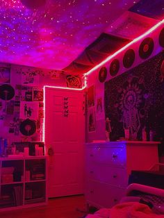 a bedroom with pink lights and pictures on the wall