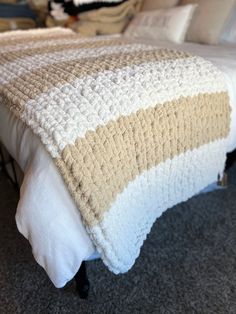 a bed with a white and brown blanket on top of it