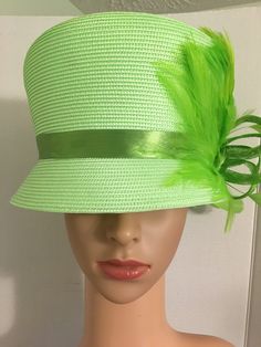 Formal, bright green, woven medium brim with a slant top, ribbon band, Sinamay ribbon and feather fan and rhinestone accent. Top hat style. 2 inch wide brim, 26 inches around, 7 inches inner width, 8 inches across top. Spring Church Hats With Feathers, Spring Formal Costume Hat With Feather Trim, Spring Formal Feather Trim Costume Hat, Spring Church Top Hat With Feathers, Formal Summer Costume Hats With Feather Trim, Green Mini Hat For Kentucky Derby And Beach, Spring Costume Hat With Feather Trim, Green Feathered Mini Hat For Wedding, Green Mini Hat With Feathers For Wedding