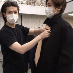 two young men wearing face masks and ties