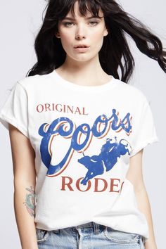 Kick back and take a wild ride with this vintage Original Coors Rodeo tee. In 1987, Coors kicked off the summer with their iconic rodeo events as a tribute to western heritage. This soft cotton fitted tee is perfect for the rodeo, with vintage distressed hems, rolled short sleeves, and a ribbed crewneck. The design of this style is fitted. For a more standard fit choose a size up. Details Style #302145 Color: White Wild Vintage Original Coors Rodeo Fitted T-Shirt 100% Cotton Care/Import Machine Retro T-shirt For Summer Country Concerts, Vintage Summer T-shirt For Rodeo, White Crew Neck Tops For Western-themed Events, Retro Summer Rodeo T-shirt, Retro Summer T-shirt For Rodeo, Rodeo Screen Print Crew Neck Top, Rodeo Crew Neck Top With Screen Print, White Graphic Tee For Rodeo, Crew Neck Top With Screen Print For Rodeo