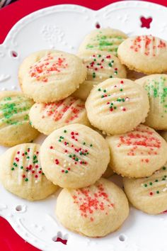 a white plate topped with sugar cookies covered in sprinkles