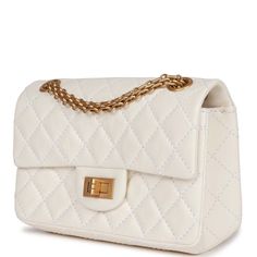 This Mini Reissue 224 2.55 Single Flap bag is in White aged calfskin with antique gold hardware, front flap with a mademoiselle turnlock closure, half moon back pocket, and interwoven gold tone chain link.The interior is lined in white leather with one zip pocket and one slip pocket on the back wall.Collection: 22A (RFID)Origin: ItalyCondition: New and never wornAccompanied by: Chanel Box, dustbag, carebook, felt, ribbon, retail UPCMeasurements: 5" width x 7.8" height x 2.75" depth; 11" strap dr Timeless Bags, Chanel Box, Chanel Mini, Madison Avenue, Parisian Chic, Classic Flap, Flap Bag, Half Moon, White Bag