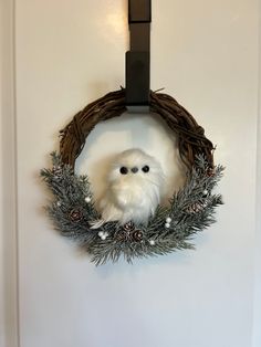 an owl is sitting in a wreath on the door