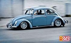 a blue vw bug driving down the street