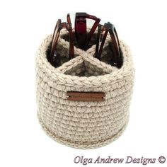 a crocheted storage basket with wooden handles