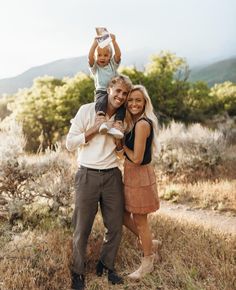 a man and woman holding a baby in the air