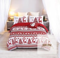 a bed with red and white christmas decorations on the comforter, pillows and sheets