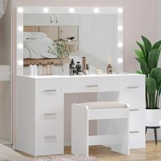 a white vanity with lights on it and a mirror in the corner next to a bed