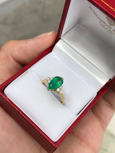 a person is holding an emerald ring in their hand and it's inside the box