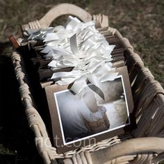 a basket filled with photos and paper on top of grass