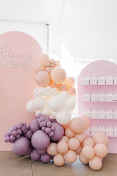 there are many balloons on the floor in front of a display shelf with bottles and jars