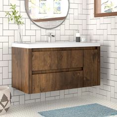 a bathroom with a sink, mirror and rug