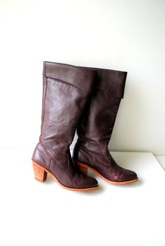 "Boho vintage 70s dark brown with a hint of burgundy, genuine leather boots. Made by Dexter in USA. Pirate style cuffed top. Chunky stocked wood heel. Lined with a brown nylon. Gently used condition. The high quality leather is clean, soft and strong. Little distressed from the front sides. But it's don't effected a value. No odor. Size 5 1/2 m. Tall ( of the back) with a heel:15,0\" Size of the heel:2,5\"x1,5\" Width of the cup up front:3,0\" Width of the opening:14,0\" Length of the insole:7,0 Vintage Brown Heeled Boots For Winter, Retro Brown Heeled Boots For Winter, Vintage Brown Heeled Boots With Stacked Heel, Vintage Brown Wide Calf Boots, Brown Vintage Wide Calf Boots, Retro Brown Boots With Leather Lining, Brown Boots With Wooden Heel For Fall, Vintage Leather Heeled Boots With Stacked Heel, Pirate Style