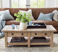 a living room with a couch, coffee table and books on the shelf in front of it