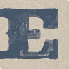 the letter e is made up of black and white paint on beige paper with blue ink