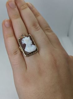 This gorgeous vintage cameo ring is beautifully crafted in a solid 14k gold frame with details at every angle. The victorian style is likely a 1930-1950s creation. In the center is a carved shell cameo of a Roman soldier. The cameo is in excellent condition and the sturdy ring measures approximately 26.45mm tall (including gold filigree fame) x 17.37mm wide. The ring is currently a ring size 7.5 but can be resized by your trusted local jeweler. A bold statement ring for men and women who love an Antique Cameo Ring Collectible, Gold Cameo Signet Ring Collectible, Victorian Gold Cameo Rings, Gold Signet Ring With Cameo Collectible, Vintage 14k Gold Cameo Rings, Cameo 14k Gold Rings For Collectors, Collectible 14k Gold Cameo Rings, 14k Gold Cameo Rings For Collectors, Vintage Cameo Signet Ring