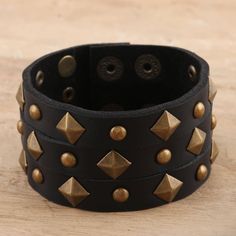 Covered in faceted studs, Indian artisan Deepika Lohani's eye-catching cuff is sure to add some edge to your outfit. Designed for both men and women, the cuff is hand crafted from wide strips of black leather and embellished with brass-plated iron studs. Two row of brass-plated iron snap buttons let you adjust the size to fit your wrist. Punk Cuff Bracelets With Rivets, Trendy Adjustable Spiked Bracelets, Edgy Adjustable Cuff Leather Bracelet, Adjustable Punk Cuff Bracelet With Rivets, Adjustable Punk Jewelry With Spikes, Punk Adjustable Cuff Bracelet With Rivets, Adjustable Spiked Leather Bracelet For Parties, Punk Style Adjustable Cuff Bracelet With Rivets, Adjustable Spiked Punk Jewelry