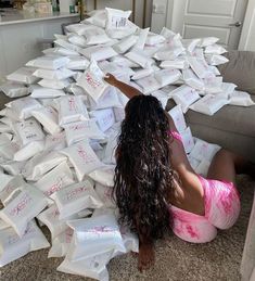 a woman is sitting on the floor surrounded by boxes that have been stacked in it