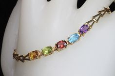 A vintage multi gemstone 14K yellow gold bracelet. Featuring 6mm x 4mm faceted ovals of amethyst, blue topaz, peridot, citrine and garnet gives this spectrum of colors a rainbow look. With a little sparkle! This is a vintage and pre owned bracelet, sold as is in great ready to wear condition. Measure 7" and weighs 2.6 dwt or 4.04 grams. Free shipping in the USA! Multicolor 14k Gold Jewelry For Formal Occasions, Formal Multicolor 14k Gold Jewelry, Yellow Gold Multi-stone Oval Bracelets, Yellow Gold Multi-stone Oval Bracelet, Yellow Gold Oval Bracelet With Multi-stone, Yellow Gold Oval Multi-stone Bracelet, Elegant Multi-stone Rainbow Gemstones, Multicolor Faceted Jewelry For Formal Occasions, Multicolor Multi-stone 14k Gold Bracelets