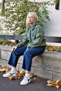 a woman sitting on a bench with her legs crossed Winter Khaki Hoodie With Relaxed Fit, Khaki Relaxed Fit Hoodie For Fall, Relaxed Fit Khaki Hoodie For Fall, Streetwear Green Hoodie With Pockets, Khaki Hoodie With Drawstring Hood And Relaxed Fit, Khaki Hoodie For Winter Streetwear, Green Sweatshirt With Pockets For Streetwear, Winter Khaki Hoodie For Streetwear, Green Hoodie With Ribbed Cuffs For Streetwear