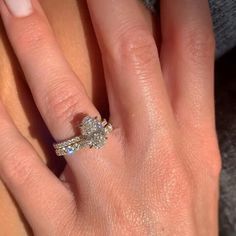 a woman's hand with two engagement rings on top of her finger and the other half