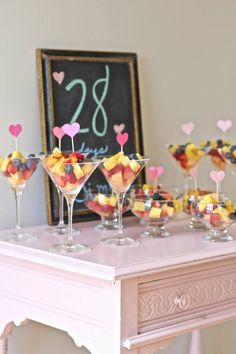 a table topped with martini glasses filled with fruit