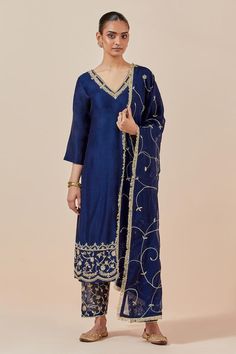 Blue straight kurta in chanderi silk base with floral embroidered hem. Comes with embroidered hem pant and tissue organza dupatta.
Components: 3
Pattern: Embroidered
Type Of Work: Floral Pattern
Neckline: V-Neck
Sleeve Type: Straight Three Quarter
Fabric: Chanderi Silk, Tissue Organza
Color: Blue
Other Details: 
Attached lining
Embroidered hem pant
Elasticated back waistband
Length:
Kurta: 47 inches
Pant: 37 inches
Approx. product weight (in kgs): 1.5
Occasion: Wedding - Aza Fashions Traditional Silk Kurta With Sheer Dupatta, Straight Kurta With Sheer Dupatta In Tussar Silk, Silk Kurta With Sheer Dupatta For Transitional Season, Traditional Tussar Silk Palazzo Set With Sheer Dupatta, Straight Tussar Silk Kurta With Sheer Dupatta, Transitional Silk Kurta With Sheer Dupatta, Unstitched Silk Kurta With Cutdana, Semi-stitched Silk Kurta With Dori Work, Silk Kurta With Zari Work For Navratri