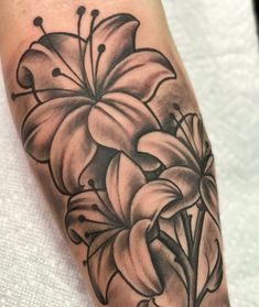 a black and white flower tattoo on the left arm, with flowers in the center