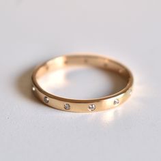 This simple yet beautiful band is 2mm wide, with flush set diamonds that go all around the band, spaced apart. Crafted in 14K Solid Gold, it makes for a perfect gift for any occasion and a great match for any ring! * Diamond Wt. : 0.08 Cts * Color-Clarity Grade : H-I, Vs-Si * Gold - 14kt Solid Yellow Gold * Band Width - 2 mm Presented in a lovely gift box. ------------------ 1mm Diamond Band : https://www.etsy.com/in-en/listing/537627294/5-diamond-ring-1mm-flush-set-diamond-14k?ref=shop_home_act Flush Set Diamond, Diamond Eternity Wedding Band, Diamond Ear Cuff, Gold Stacking Ring, Sapphire Wedding Band, Sapphire Wedding, Thumb Ring, Gold Ring Stack, Eternity Wedding Band