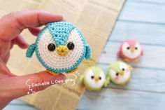 a small crocheted owl sitting on top of a piece of paper next to three little birds