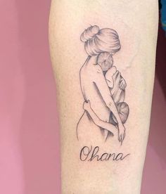 a woman's leg with a tattoo on it that reads, ohana and is holding a baby