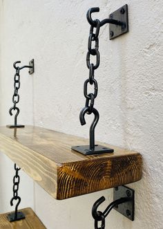 a wooden shelf with chains hanging from it's sides and hooks attached to the wall