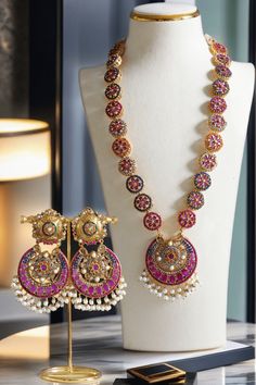 Step into the extravagant fusion of grace and royalty with the "Adiva - Long Mala Necklace Set." This opulent set paints you in luscious shades of multi-color stones and embellishments, elevated by pearl moti hangings. It features a classic embodiment of a beautiful flower motif design that exudes elegant femininity.The set includes a beautifully crafted mala with an adjustable dori for a perfect fit and a pair of dangle earrings, each designed to enhance your regal charm. With an approximate ma