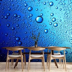 three chairs and a table in front of a blue wall with water drops on it