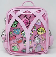 a small pink backpack with lots of stickers on it's front and sides