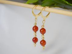 Carnelian Dangle Earrings Gold, Red Orange Carnelian Gemstone Huggie earrings, Carnelian Jewelry, Natural Stone, Jewelry Gift For Her. ⭐ Handmade beautiful classy gold plated dangle earrings with natural carnelian stone in orange red. ⭐ Materials used:-  Earrings  ✧ High quality gold plated 304 stainless steel lever back hoop earrings, gold plated stainless steel beads,  Hoop Size:- 14.5 x 12 mm ✧ Natural stone carnelian beads.  Toatal length of earrings including hoop 40mm (4.0cm) ⭐ Packing: Carefully packaged and ready to give as a gift. If you want to add a note, please leave me a message with your order. ⭐ We look forward to personal inquires, do not hesitate to contact us. ☘️As these are natural gemstones, the color may vary and the pair ordered will be shipped based on stock. Please Red Agate Dangle Earrings, Red Carnelian Pierced Earrings, Carnelian Gemstone Dangle Earrings, Carnelian Dangle Earrings With Natural Stones, Carnelian Natural Stones Dangle Earrings, Nickel-free Red Carnelian Earrings, Red Carnelian Earrings With Ear Wire, Carnelian Round Earrings With Ear Wire, Nickel Free Carnelian Dangle Earrings