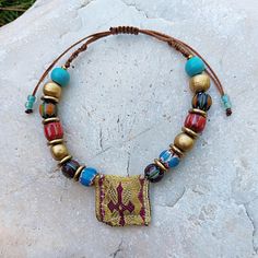 Discover the beauty and spiritual significance of this unique handmade Greek talisman amulet bracelet. Adorned with vibrant, multi-colored nepalese beads, wooden beads , bronze details and a distinctive fabric Greek amulet centerpiece, this bracelet combines traditional craftsmanship with a modern boho style. The adjustable cord ensures a comfortable fit for any wrist size. Perfect as a meaningful gift or a special addition to your own jewelry collection, this piece carries the essence of ethnic Bohemian Hand-strung Friendship Bracelets For Festivals, Multicolor Hand Wrapped Beaded Bracelets For Meditation, Traditional Handmade Beaded Bracelets For Meditation, Spiritual Hand-wrapped Beaded Bracelets For Festivals, Spiritual Hand Wrapped Beaded Bracelets For Festival, Bohemian Beaded Bracelets For Festivals And Gifts, Bohemian Friendship Bracelets For Meditation, Artisan Handmade Bracelets For Meditation, Bohemian Gold Beaded Bracelets For Meditation