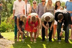 a group of people standing next to each other on top of a lush green field