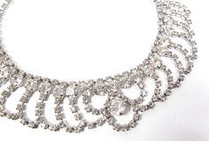 "1950s Clear Glass Rhinestone Choker Necklace Vintage Wedding Collar Tiara Vtg This gorgeous vintage piece is made of sparkling clear rhinestones. Beautiful design, circa 1950s. All the rhinestones are present and full of fire, no missing, and no dull stones. Set on silver tone metal with hook clasp. The necklace is a choker or collar and measures 1-1/2\" wide (at widest point) x 15\" long. Very pretty! Shows minimal wear if any. Excellent condition! Please see all photos and check our other lis Vintage Crystal Necklaces For Weddings, Vintage Crystal Bridal Necklace, Vintage Sparkling Diamond Jewelry, Vintage Round Bridal Necklace For Anniversary, Vintage Wedding Necklaces With Sparkling Stones, Vintage Cubic Zirconia Necklaces For Weddings, Vintage Cubic Zirconia Wedding Necklaces, Vintage Rhinestone Necklace For Wedding, Vintage Rhinestone Necklace With Sparkling Stones For Wedding