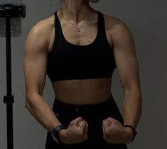 a woman standing in front of a camera with her hands on her hips and looking at the camera