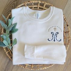 This listing is for our beautiful, custom embroidered Marian Monogram  Sweatshirt, a great way to wear and show a Marian devotion to our Mother Mary. It is cute, SUPER comfortable and soft, and a Catholic piece of clothing that  would be a perfect gift for a birthday, Christmas, appreciation gift, sweatshirt to wear at home, or out and about!  SIZING: Please be sure to see the size chart picture. These are a unisex fit, so they will be a looser fit if you order your normal size.  This custom cre Customizable White Top With Custom Embroidery, Marian Devotion, Catholic Clothing, Custom Crewneck Sweatshirts, Catholic Women, Monogram Sweatshirt, Psalm 91, Men Sweatshirt, Mother Mary