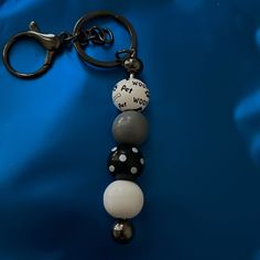 a black and white beaded keychain on a blue background with the word work written across it