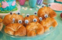 some croissants with googly eyes on them are sitting on a table