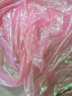 some pink plastic bags on the ground and one bag is wrapped in clear plastic wrap