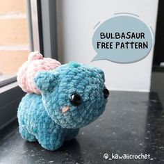 a small blue crocheted elephant sitting on top of a counter next to a window